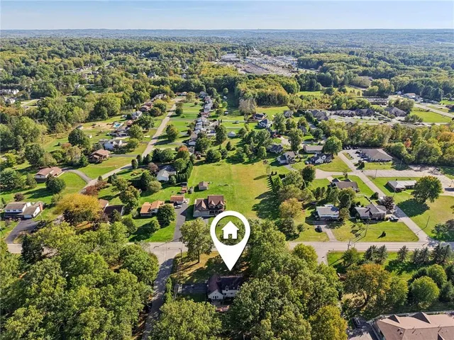 an aerial view of a residential houses with outdoor space and parking
