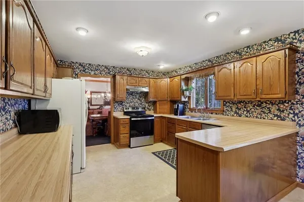 a kitchen with granite countertop a sink stove and refrigerator
