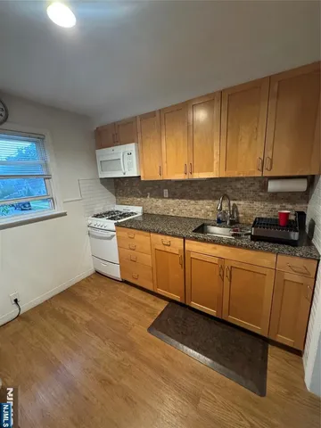 a kitchen with granite countertop a sink and cabinets