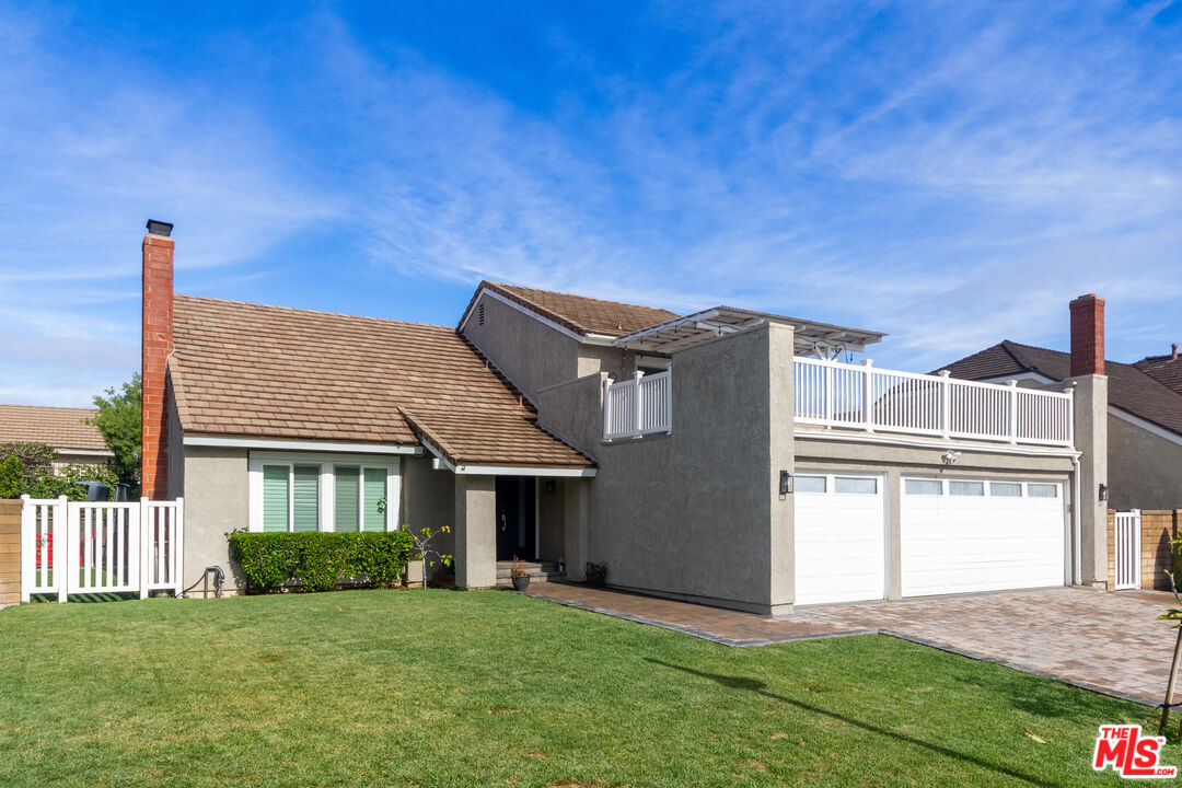 a front view of a house with a garden and yard