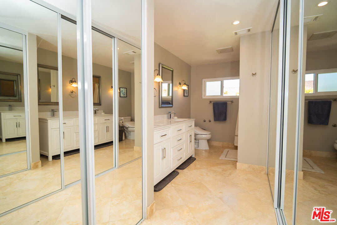 879 Shadowgrove Street Brea, CA 92821 - Photo 20 of 37 a bathroom with a glass door shower a sink and a mirror