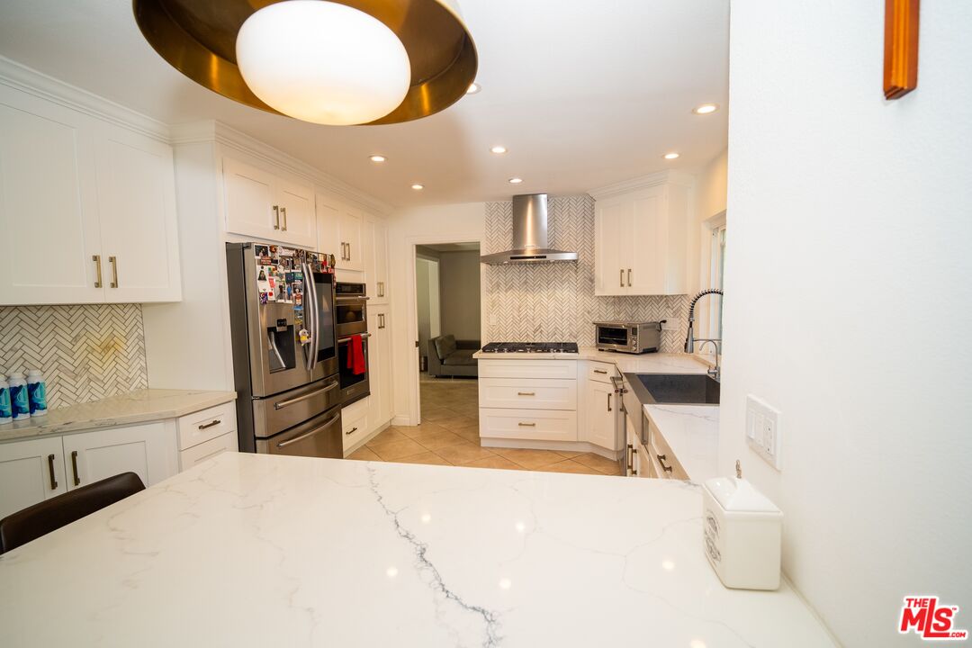 879 Shadowgrove Street Brea, CA 92821 - Photo 10 of 37 a kitchen with stainless steel appliances kitchen island granite countertop a sink refrigerator and cabinets