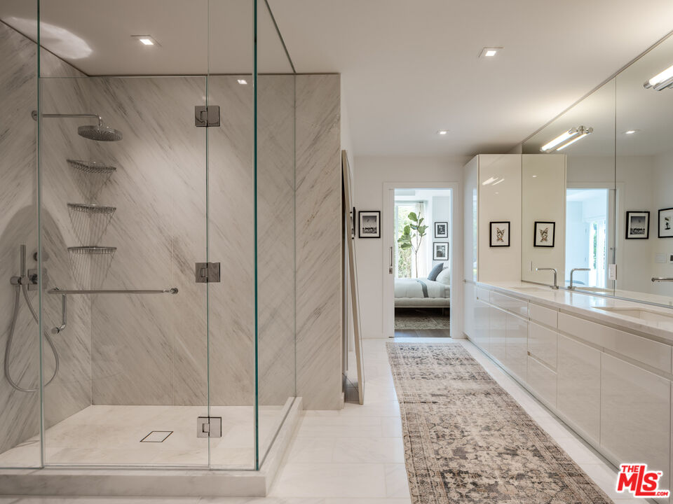9000 West 3rd Street, Unit 103 Los Angeles, CA 90048 - Photo 10 of 27 a bathroom with a glass shower door and a bathtub