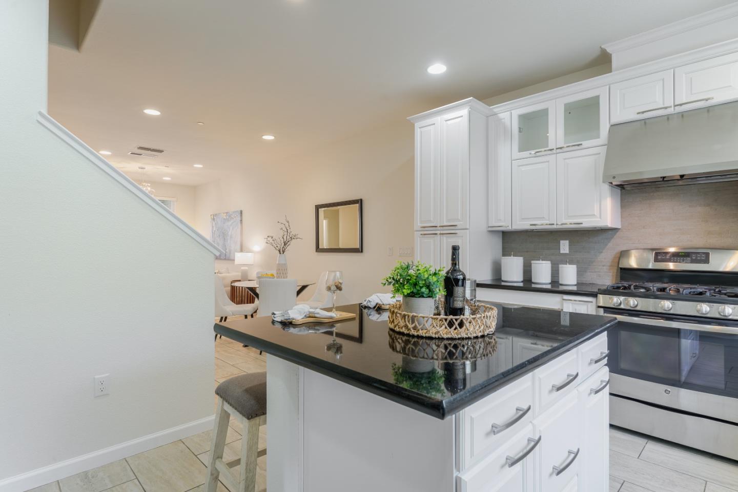 a kitchen with stainless steel appliances granite countertop a sink stove and cabinets