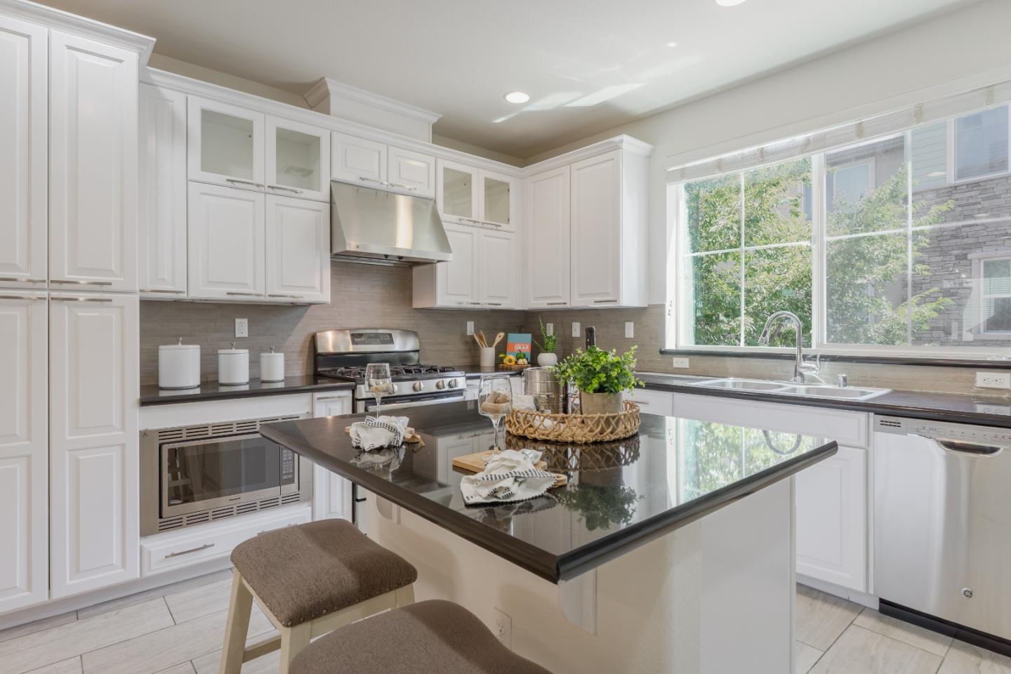 862 White Moonstone Loop San Jose, CA 95123 - Photo 14 of 54 a kitchen with stainless steel appliances granite countertop a stove a sink a microwave and white cabinets