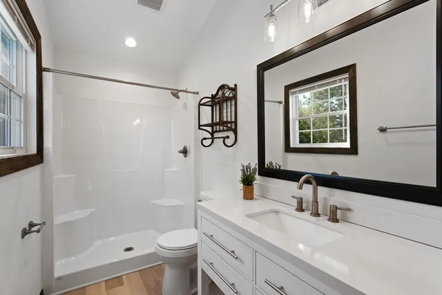 a bathroom with a sink a toilet and shower