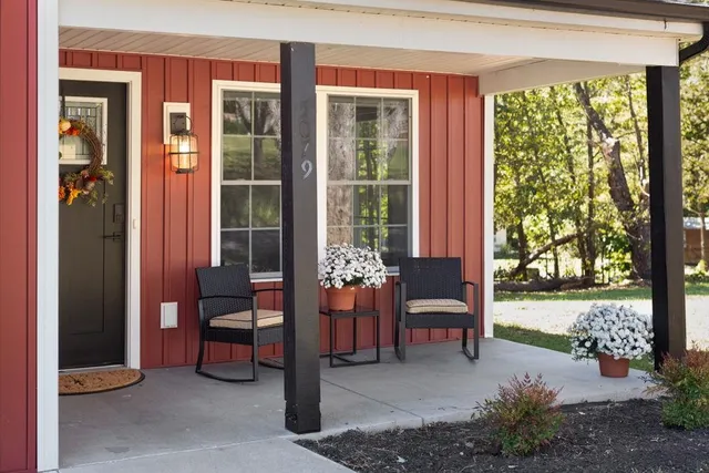 a view of a porch with chairs and potted plants