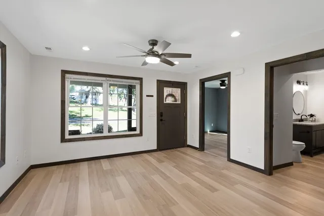 a view of an empty room with a window and a kitchen