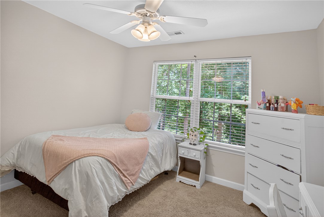 151 Towne Creek Trail Anderson, SC 29621 - Photo 27 of 49 A comfortable bedroom with a ceiling fan, plush carpet, and a pleasant outdoor view through the window.