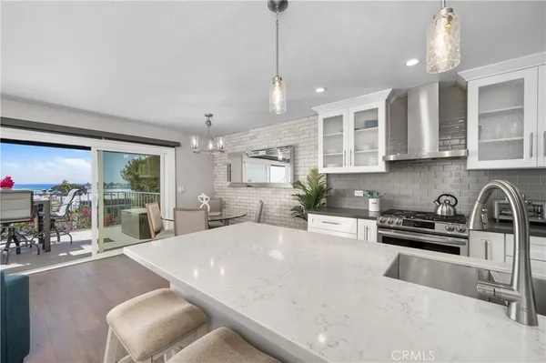 a kitchen with a dining table chairs and wooden floor
