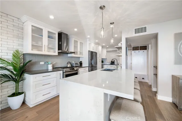 a kitchen with stainless steel appliances a stove a sink and a refrigerator