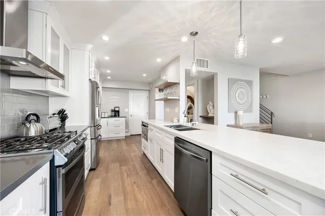 a kitchen with stainless steel appliances white cabinets and a refrigerator