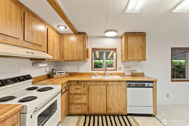 a kitchen with a sink a stove and cabinets