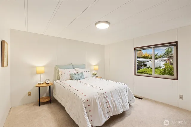 a bedroom with a bed and painting on the wall