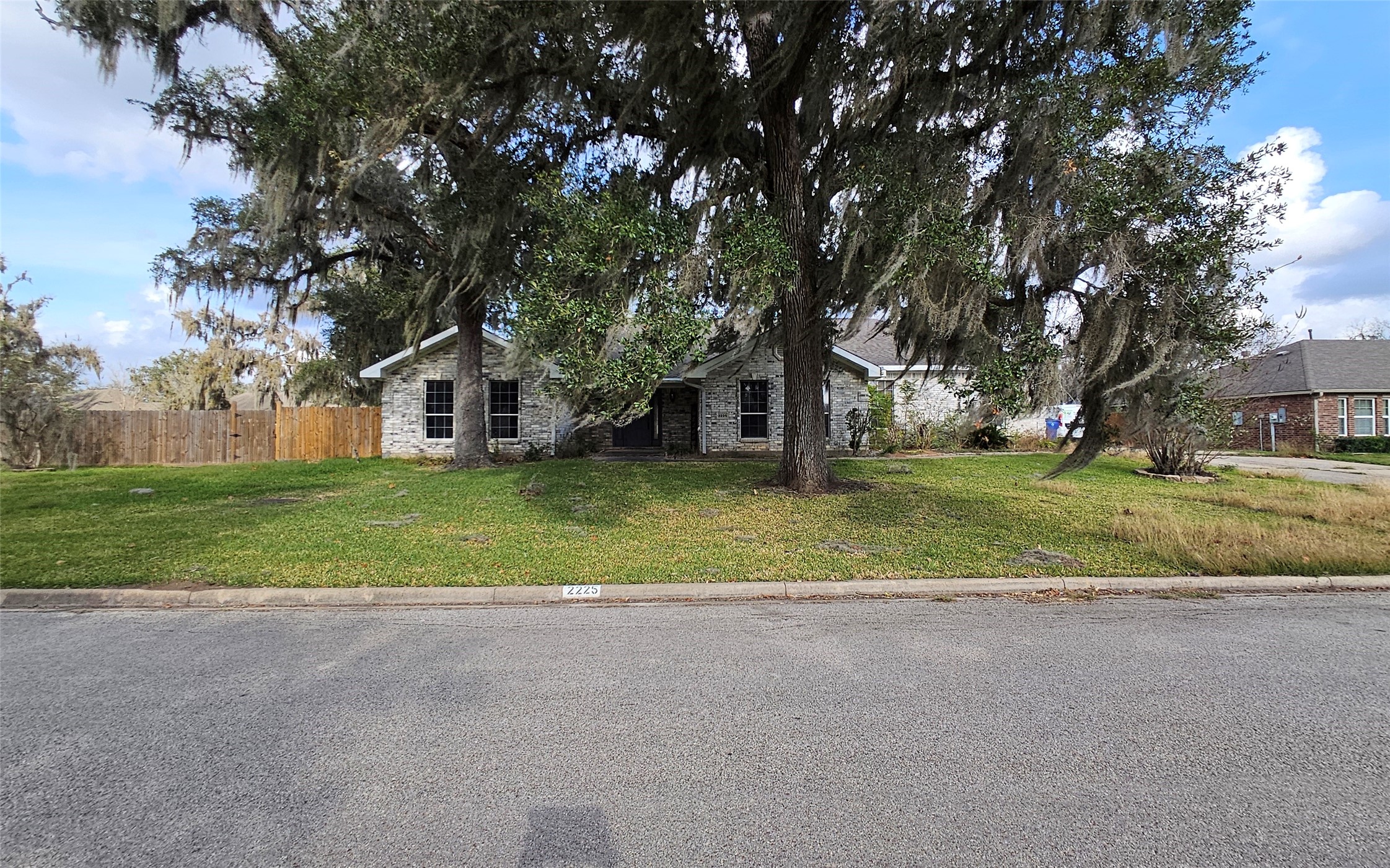 a view of a house with a big yard and large trees