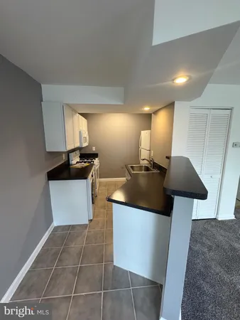 a kitchen with stainless steel appliances a stove a sink a counter top space and cabinets