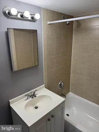 a bathroom with a sink mirror and a bathtub