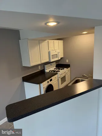 a kitchen with granite countertop a stove and a sink