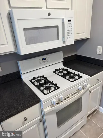 a white stove top oven sitting inside of a kitchen