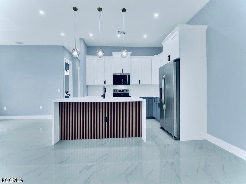 3517 2nd Street Southwest Lehigh Acres, FL 33976 - Photo 16 of 28 a kitchen with stainless steel appliances granite countertop a refrigerator a sink and a fireplace