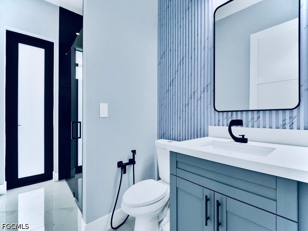 3517 2nd Street Southwest Lehigh Acres, FL 33976 - Photo 23 of 28 a bathroom with a sink toilet and mirror