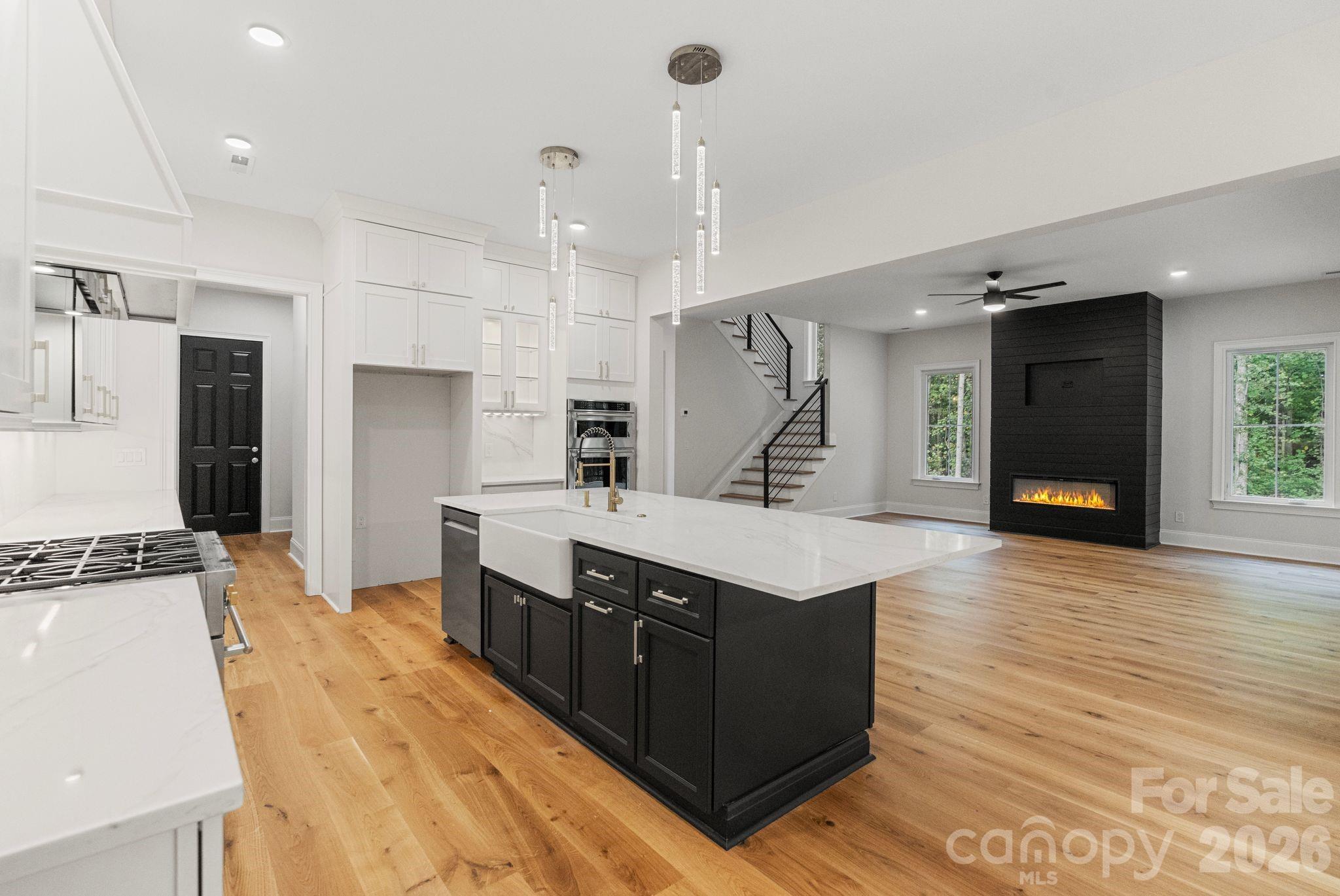 a large kitchen with stainless steel appliances a large counter top a stove a sink and a refrigerator