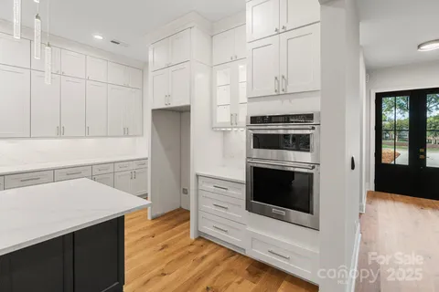 a kitchen with granite countertop white cabinets and refrigerator