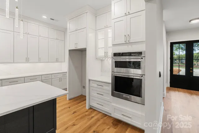 a kitchen with granite countertop white cabinets and refrigerator