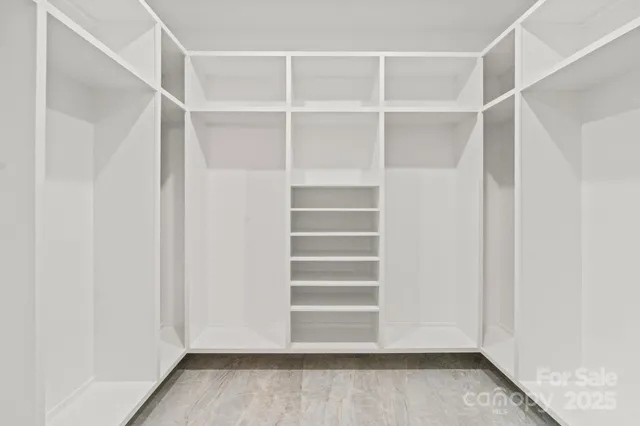 a view of walk in closet with empty racks