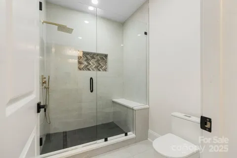 a bathroom with a shower a toilet and a sink