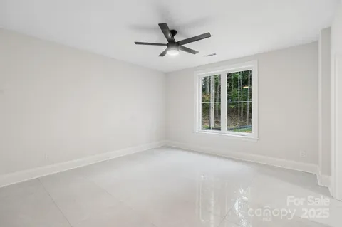 an empty room with window and ceiling fan
