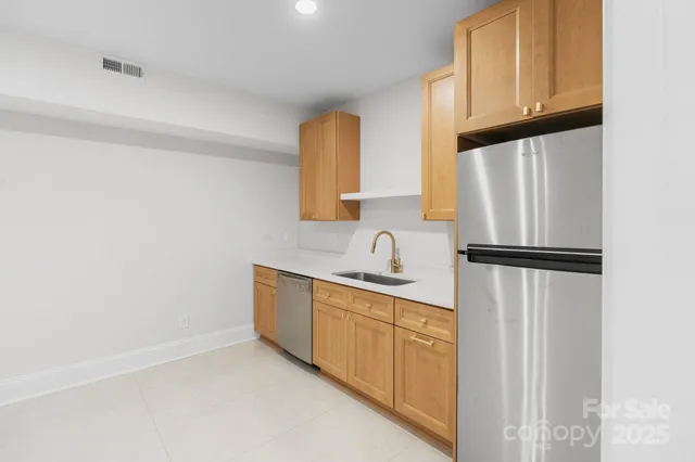 a kitchen with white cabinets and refrigerator