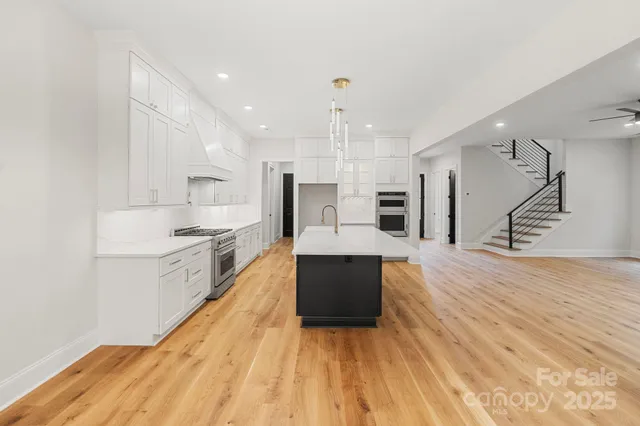 a large kitchen with kitchen island a sink stainless steel appliances and cabinets