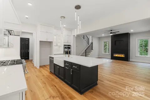 a large kitchen with stainless steel appliances a large counter top a stove a sink and a refrigerator