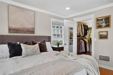 a bedroom with a bed and a painting on the wall