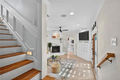 a view of a livingroom with furniture a flat screen tv and staircase