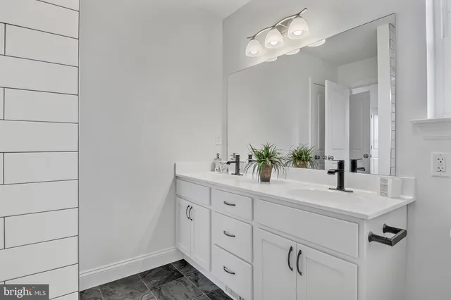 a bathroom with a double vanity sink and a mirror