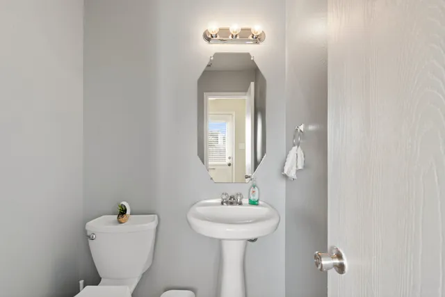 a bathroom with a toilet sink and mirror