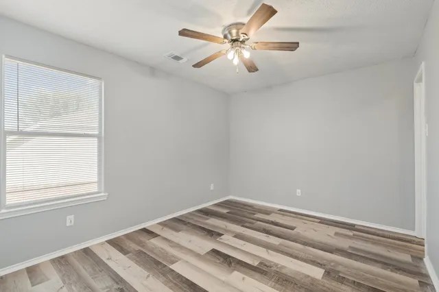 a view of a room with a ceiling fan and a window