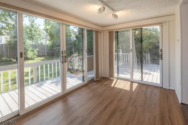 a view of a room with wooden floor and floor to ceiling windows
