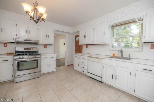 a kitchen with cabinets appliances a sink and a window
