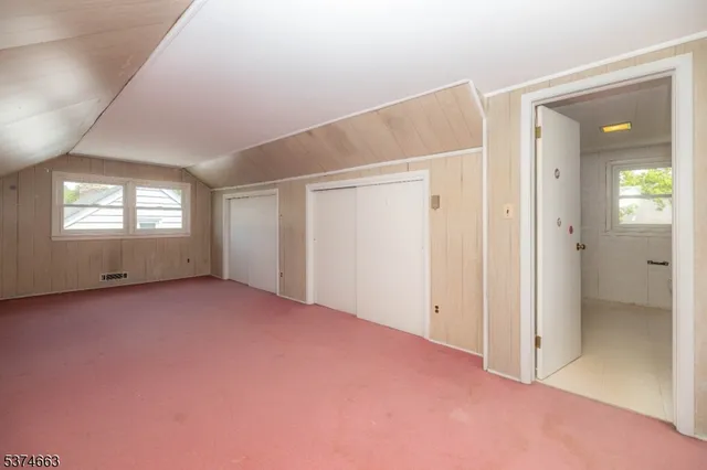 an empty room with windows and closet