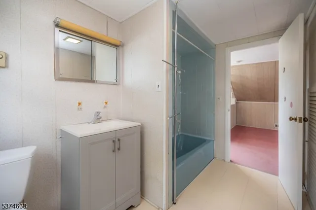 a bathroom with a sink and mirror with toilet