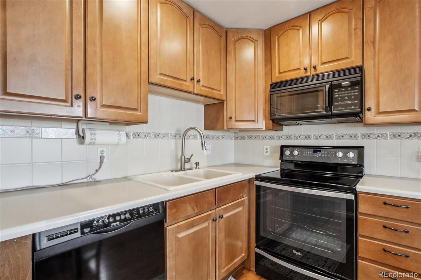 6689 South Delaware Street Littleton, CO 80120 - Photo 12 of 25 a kitchen with granite countertop a stove a sink and a microwave
