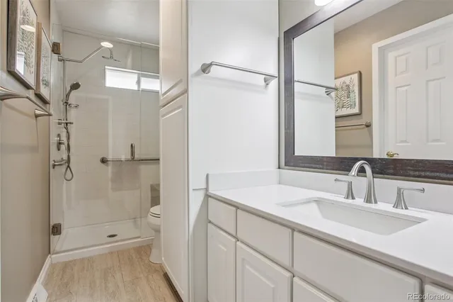 a bathroom with a shower sink vanity and mirror