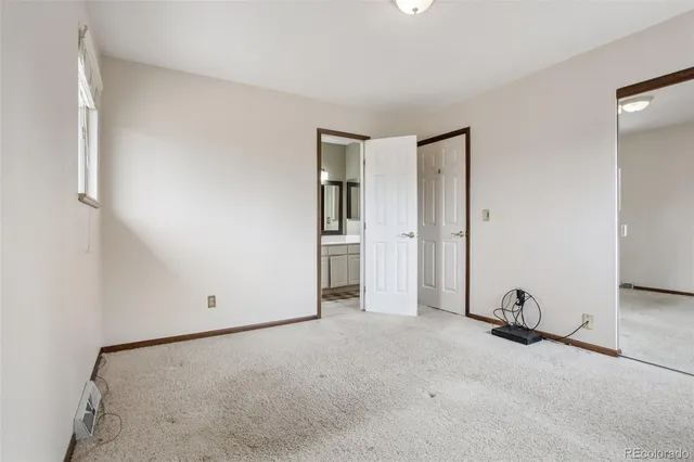 an empty room with closet and mirror