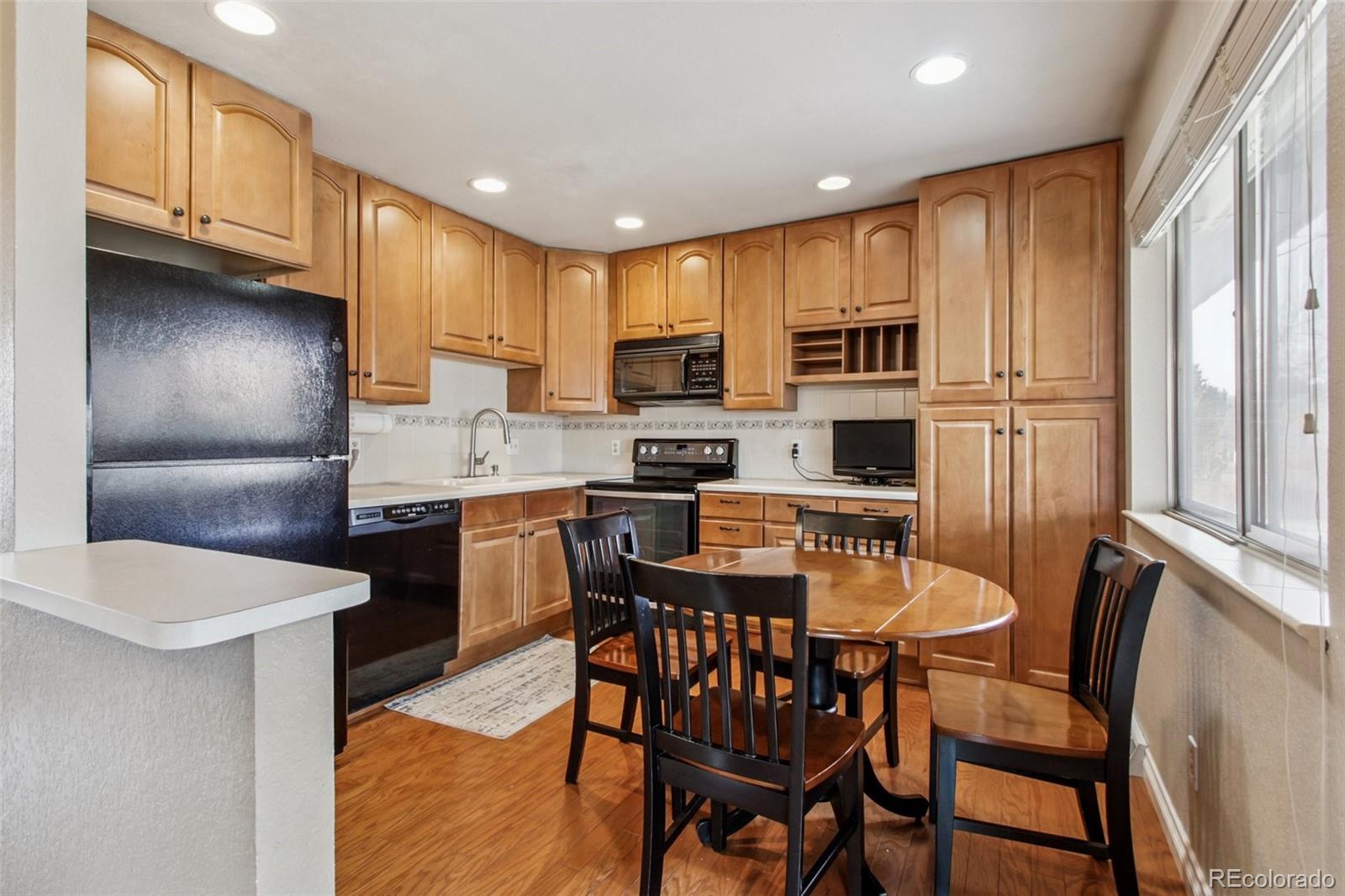 6689 South Delaware Street Littleton, CO 80120 - Photo 10 of 25 a kitchen with a table chairs microwave and cabinets
