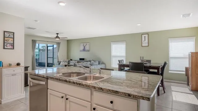 a kitchen with granite countertop kitchen island a sink and a stove