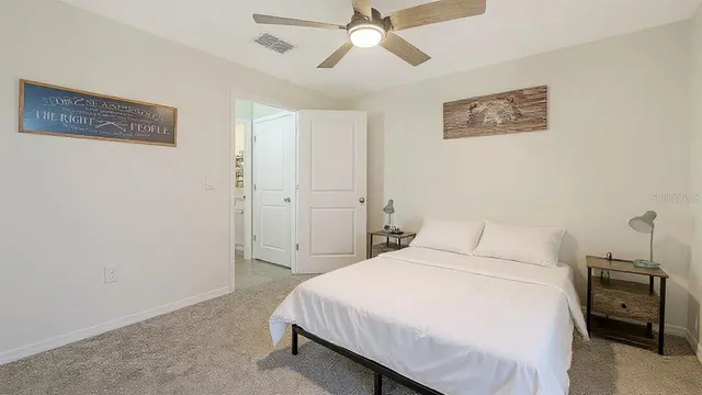 a bedroom with a bed and a ceiling fan