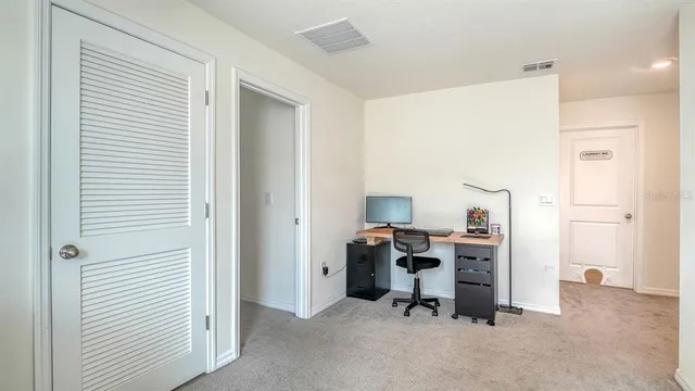 a view of a workspace with furniture and a window
